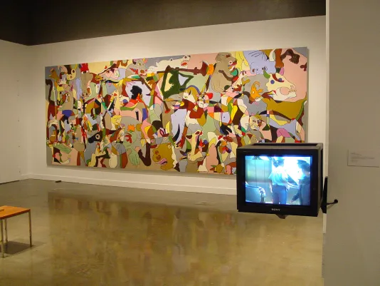 A colorful, abstract work covers the gallery wall and to the right, a box tv monitor is mounted to the wall