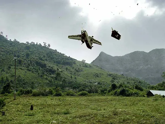 A photo of a plane that appears to be crashing in an empty mountainside. 