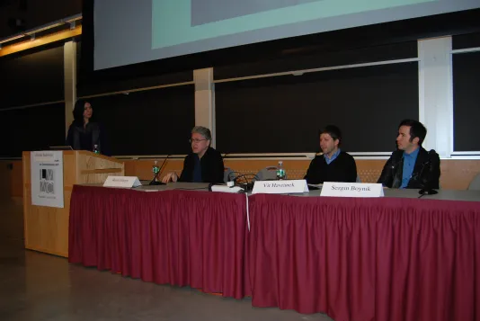 Three people sit at a table at the MIT List Center Wasserman Forum.
