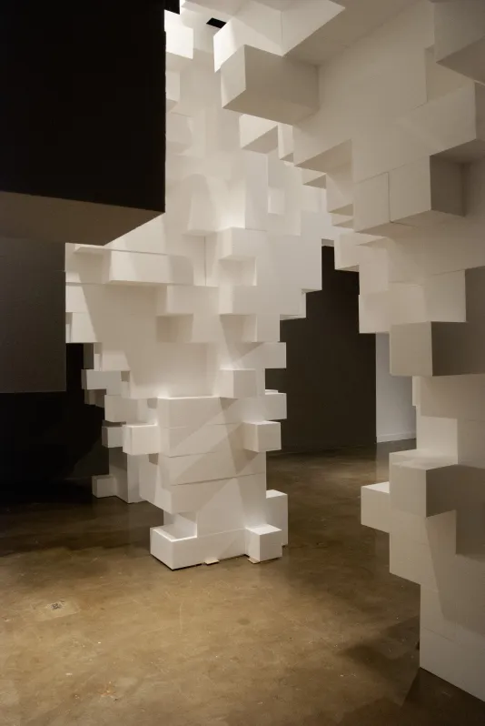 Dense geometric form give way to eroded, irregular-shaped footings made of white Styrofoam™ blocks.