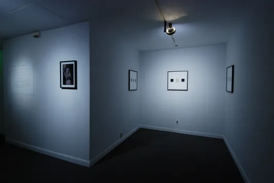4 photography works framed in black and text on 4 white walls of the gallery.