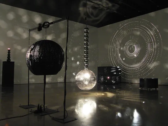 Installation in a dark room filled with mirrored balls.