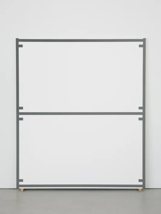Large canvas edged and bisected with a uniform gray line, as well as 8 evenly spaced short lines, leans against a wall.