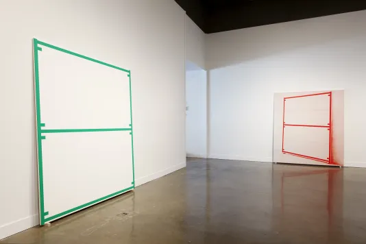 A canvas edged and bisected with a green line and a screened image of a rectangle edged and bisected with a red line.