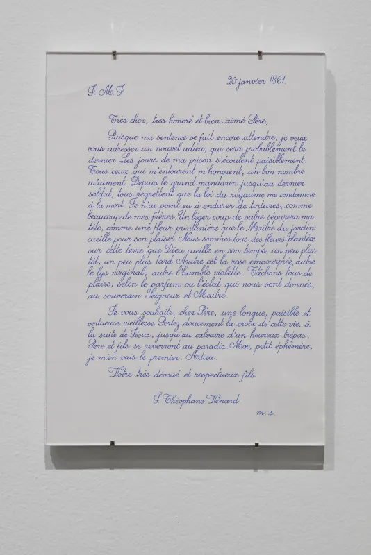 Written in French with blue ink, a document clipped behind glass and dated “20 janvier 1861” hangs on a white wall
