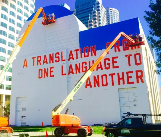 Weiner’s mural, A Translation From One Language To Another, being installed on the Greenway Wall, 2015.