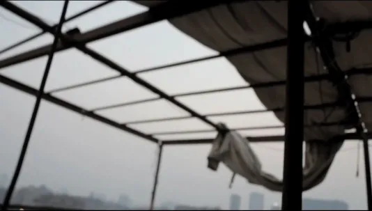 The silhouette of a building structure in front of a sky background.