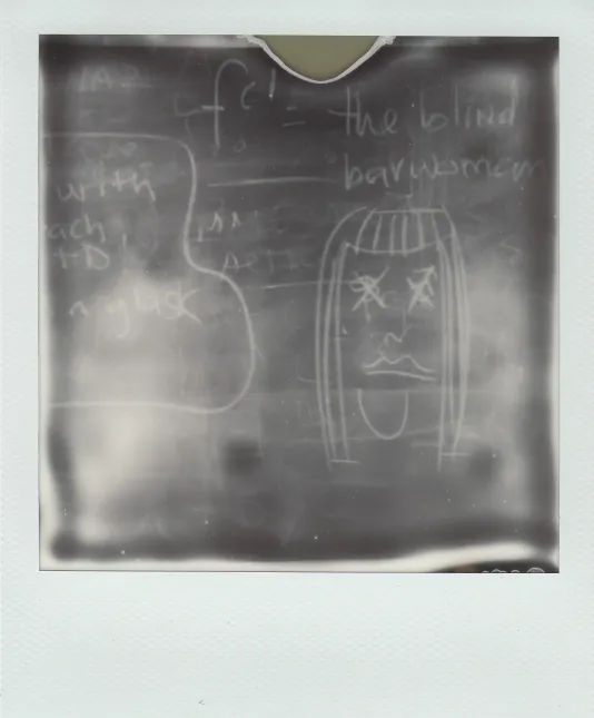 Fogged image of symbols, drawing and words in white chalk on black surface