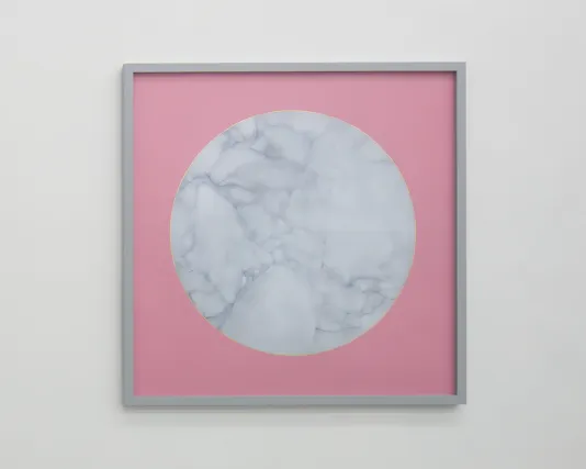 Gray square frame surrounds a painting of a circle of white veined marble, outlined with gold leaf on pink paper.