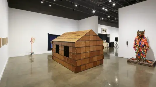 A gingerbread house installation by Nayland Blake is featured at the MIT List Visual Art Center galleries.