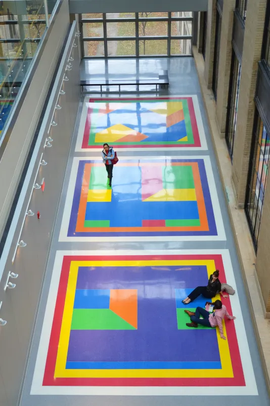 Visitors walk and sit on Bars of Color Within Squares by Sol Lewitt on MIT campus.