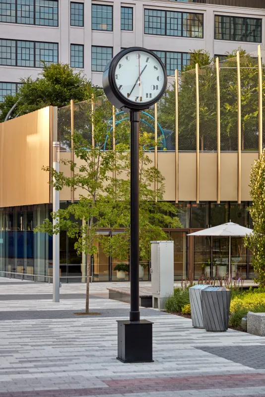  A freestanding clock with a restrained modern design sits seamlessly into the built environment of the Kendall Open Space plaza