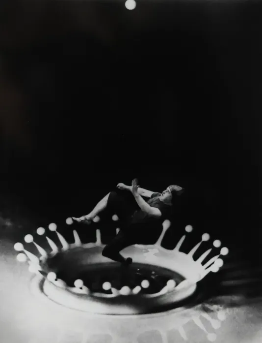 A man jumps through a droplet of milk as it splashed onto the surface