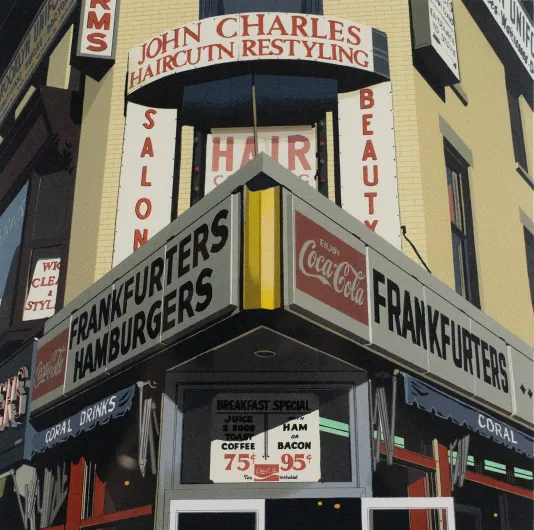 Photograph of a building corner that reads "Frankfurters Hamburgers" with other signs in the backbend for a beauty salon.