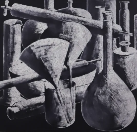 Black and white still life including beakers, funnels, glasses and vases in the background covering most of the frame