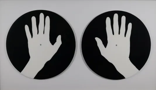 Two black circles with white prints of a hand in each.