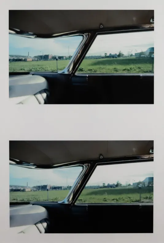 Two photographs on top of one another of the view from inside a car looking out at a green field.