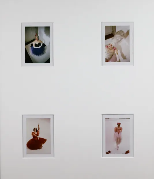 Four small photographs in a white frame of ladies wearing red, white, pink, and orange ballerina dresses.