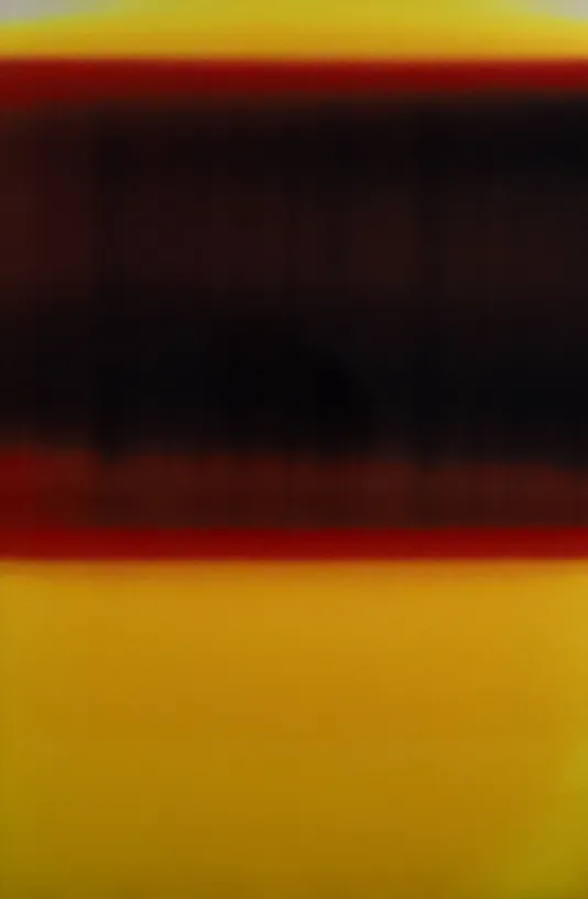 Close up of a roll of film featuring a dark strip at the top and a yellow background.