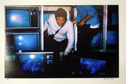 Person coming out of a hidden door inside a row of old fashioned television screens.