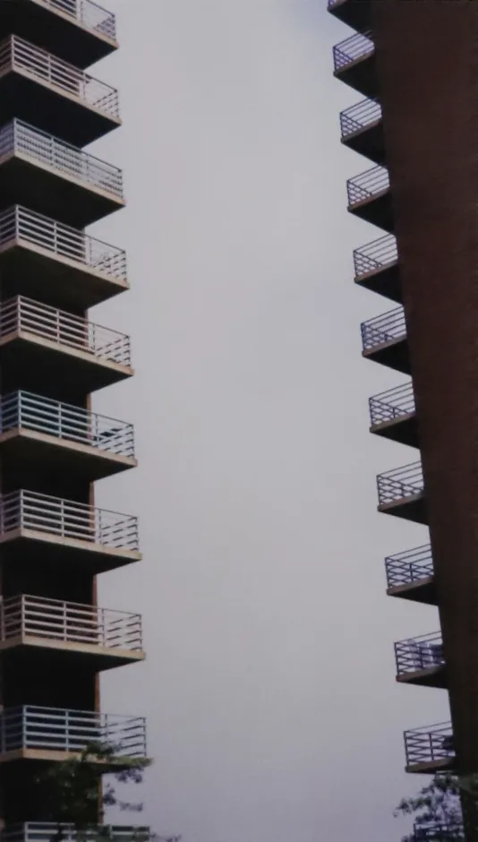 Vertical photograph of two rows of balconies on a tall housing project in new your city.