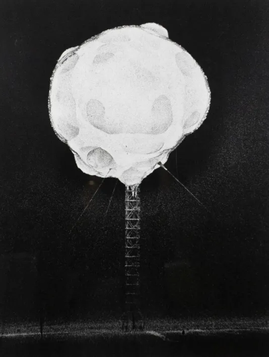 Tall metal scaffolding with a large white ball of smoke at the top.