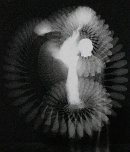 Long exposure photograph of a person waving their hand in the air.