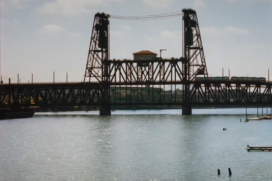 Photograph of a steel bridge of a still ocean.