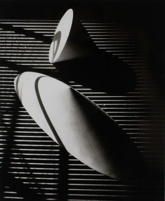 Black and white photograph of geometric shapes with deep shadows and lines creating a pattern on the surface.
