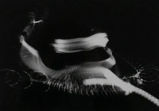 Black and white motion photograph of a ball moving through the air.