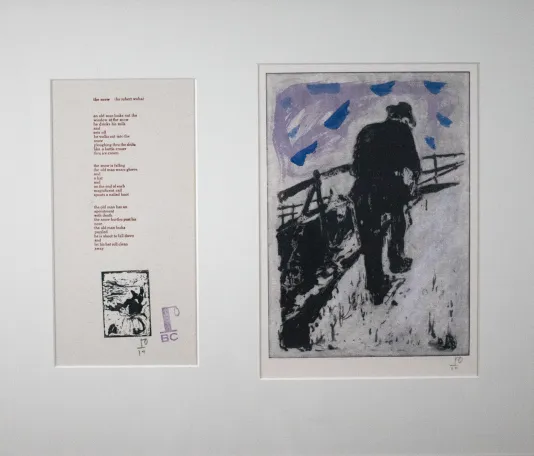 On the left, a framed poem and on the right, a print of a man walking up a steep hill.