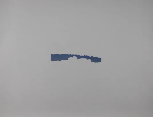 Small blue shape with jagged edges in the center of a large white plane.