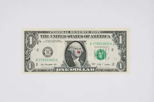 Image of a crisp one dollar bill with a red dot drawn on George Washington's nose.