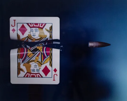A bullet flying through a jack of diamonds playing card.