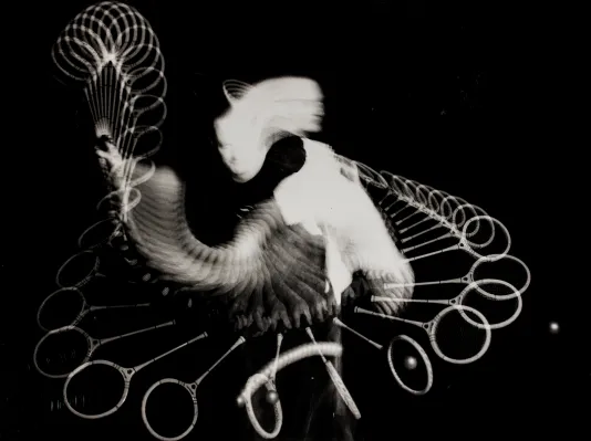 Long exposure image of a person swinging a squash racket.