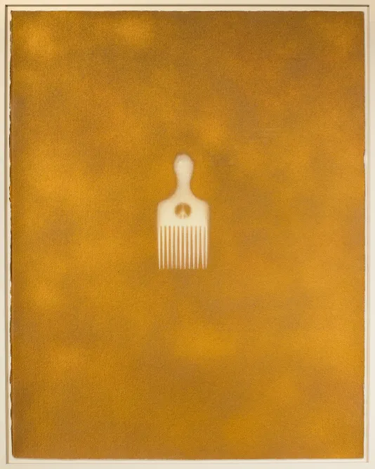 Mustard yellow blotchy background with a simple white afro pick in the center.