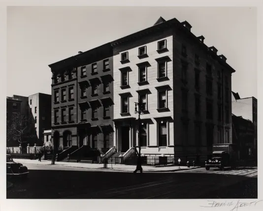 Black and white photograph of an apartment building with the left side darker than the right
