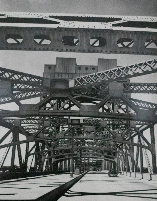 Black and white photograph of a steel bridge from underneath.
